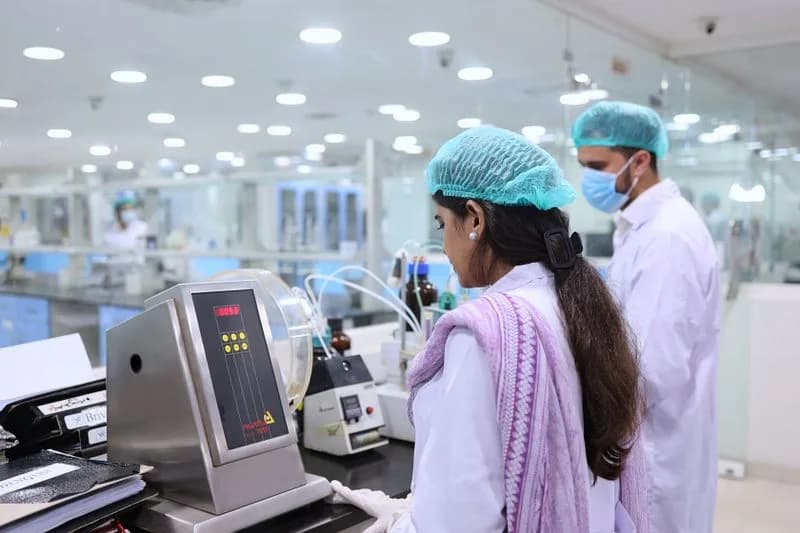 Quality control staff conducting compliance testing in a pharmaceutical lab